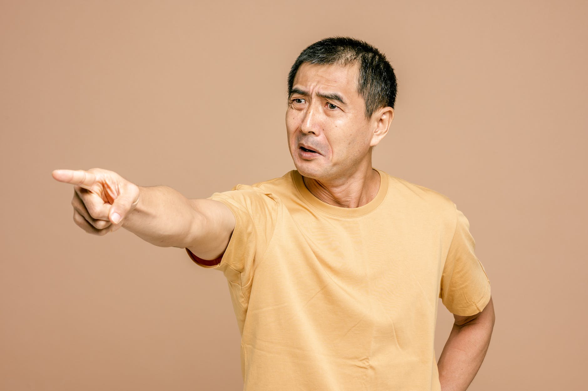 man in yellow crew neck t shirt pointing a finger