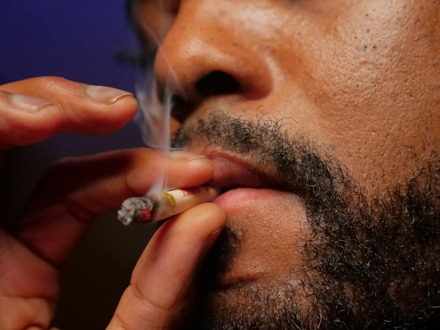 close up photo of man smoking cigarette