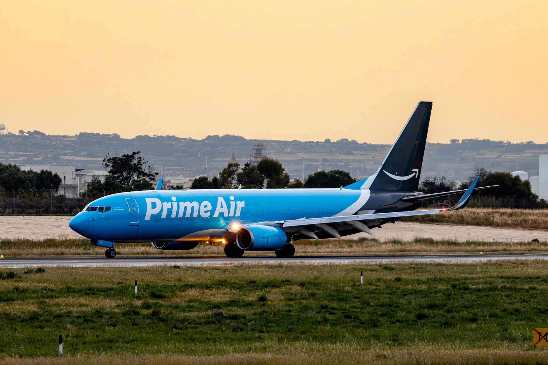 prime air cargo plane on runway at sunset