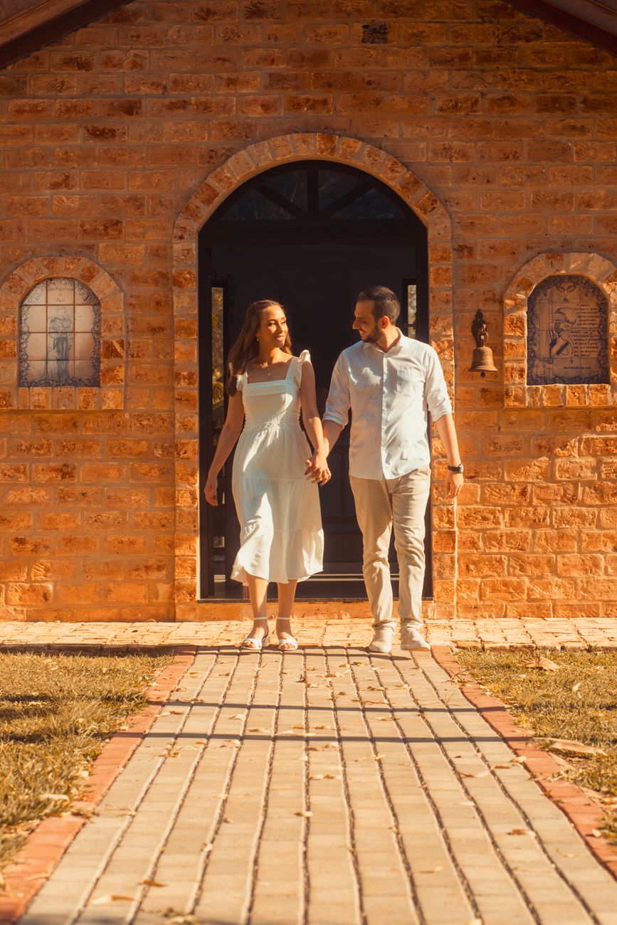 romantic couple walking outside brick building