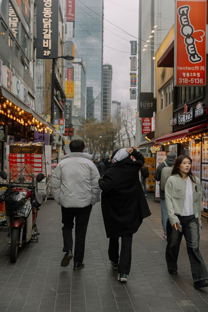 man and woman in jackets on street in city